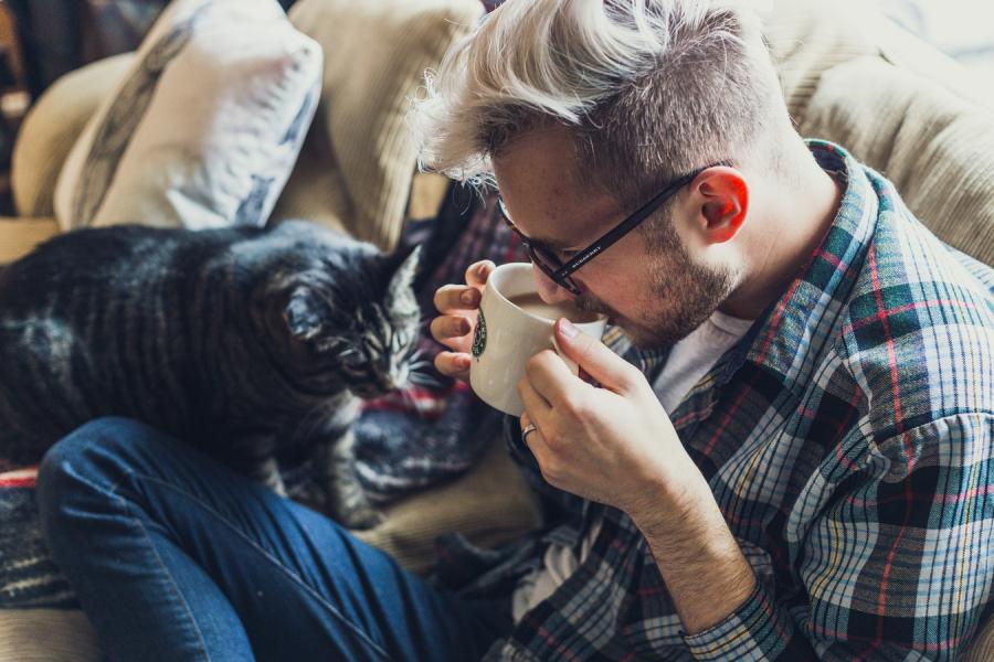 Mann trinkt Kaffee auf der Couch