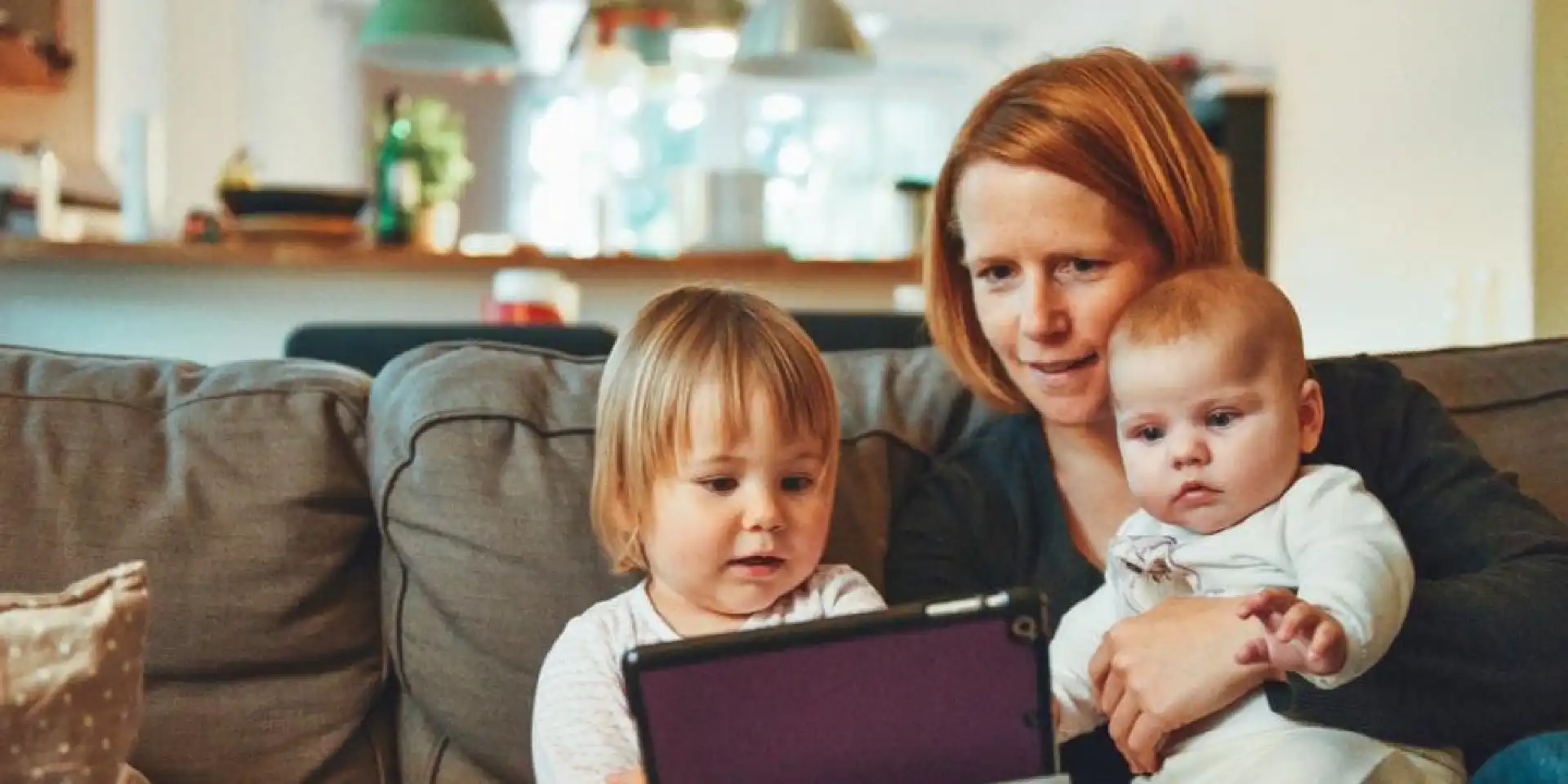 Frau mit zwei Kindern im Arm