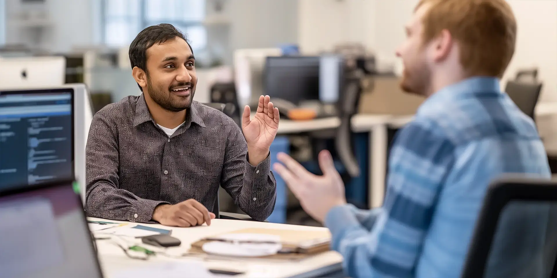 Two male IT professionals in Germany talking to each other